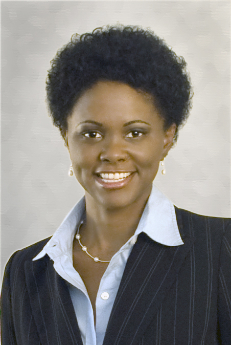 Black Woman headshot with short curly afro in blue suit. 